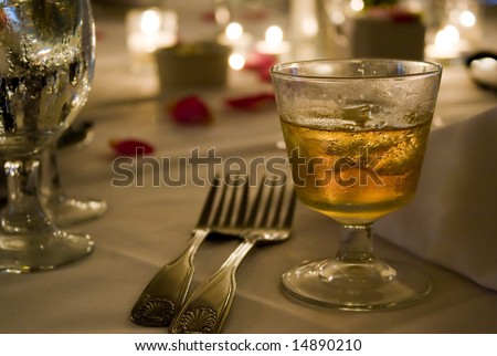 A glass of golden hard liquor on the rocks. Could be scotch, bourbon, or whiskey.
