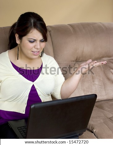 An attractive young woman working on her laptop at home.