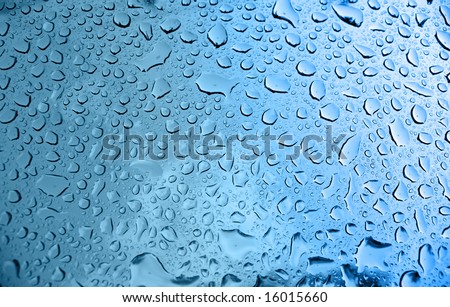 A macro of some beautiful water droplets over a blue background.
