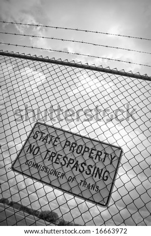 A no trespassing sign that reads STATE PROPERTY NO TRESPASSING outside an airport.