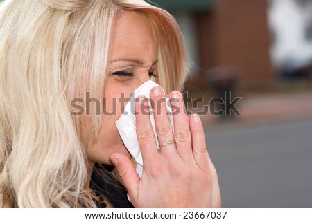 This young woman sneezing into a tissue either has a cold or really bad allergies.