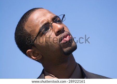 African American man wearing glasses and a business suit isolated over a blue background.