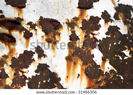 Closeup of rusted metal with chipped paint and holes.