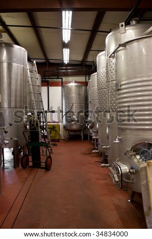 Modern aluminum storage tanks where grape juice is aged into wine located in a vineyard cellar.