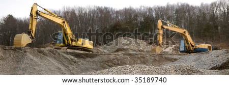 A panoramic view of a construction site with large earth movers.