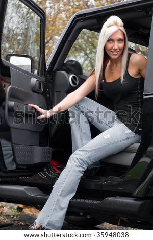 A young woman steps out of the passenger side door of a recreational vehicle.