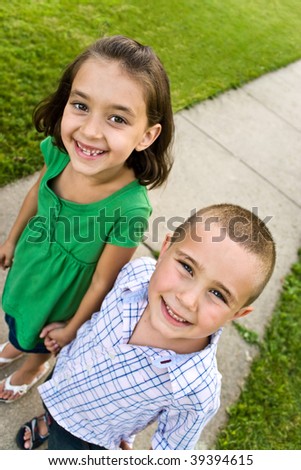 stock photo : Two little kids holding hands as they walk down the sidewalk.