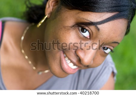 Portrait of a young Jamaican woman with a natural smile. Shallow depth of field.