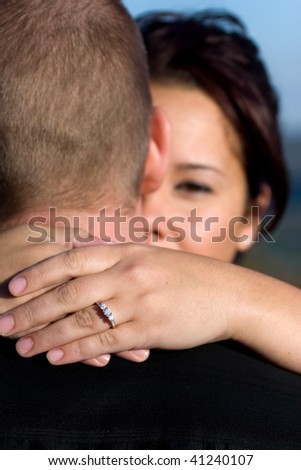 A young happy couple that just got engaged.  Shallow depth of field with focus on the diamond engagement ring.