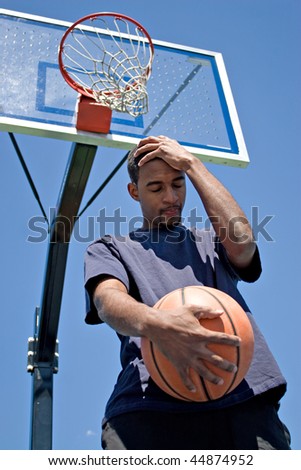 Basketball player holding his head in disappointment over losing the game.
