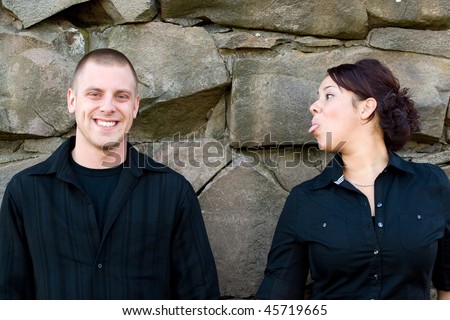 A young woman sticks her tongue out at her boyfriend or husband.