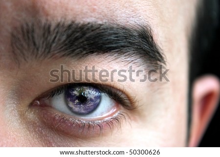 Closeup of a mans eye and eyebrow with the earth superimposed in his iris.