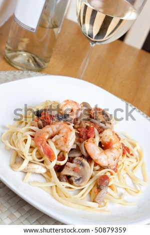 A delicious shrimp scampi over linguine dish along with a glass of pinot grigio white wine.