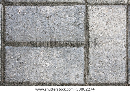 Closeup of three paver bricks in a paved stone patio floor.
