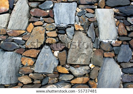 An old stone wall texture with rocks of various shapes and sizes.