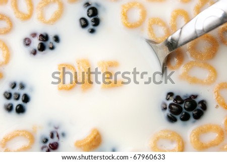 The word DIE spelled out of letter shaped cereal pieces floating in a milk filled cereal bowl.