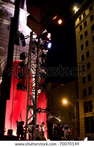 An outdoor musical event with a stage set up in the city streets.