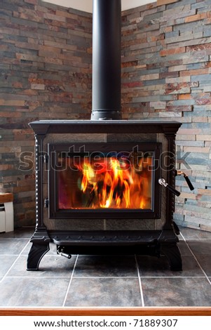 A new cast iron wood stove burning hot with slate tile.