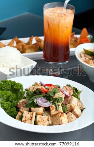 A nice assortment of Thai food and appetizers presented beautifully with fancy garnish with copy space.