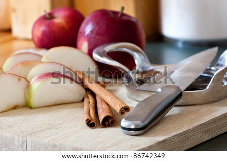An apple is sliced up into wedges on a cutting board. This is the start of preparation to making a homemade apple pie.
