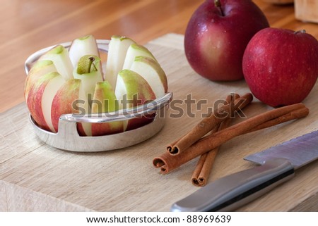 An apple is sliced into wedges and cored using a handy kitchen tool.