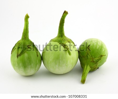 fresh organic green eggplant with drops of water on white background.