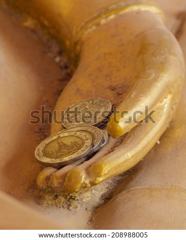 Money donation for Buddha, Concept idea of rich life. Close up hand of golden buddha statue holding coin., Concept idea of rich life. Close up hand of golden buddha statue holding coin.