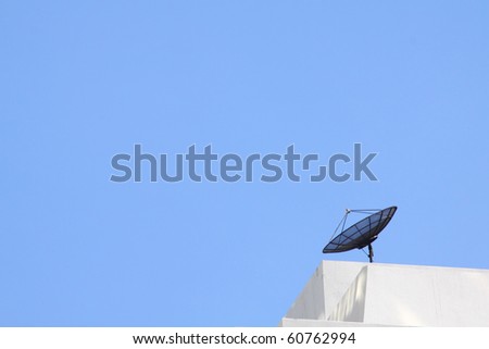 small satellite dish on building with blue sky.