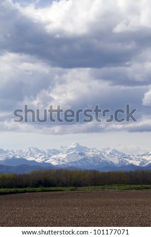 Stormy weather over a rural landscape with Alps in the background, Italy