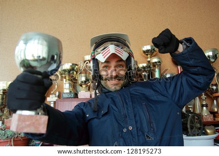 Motorcyclist pose with a victory cup