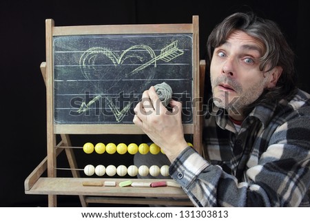 end of love concept,sad man erasing an heart sketch on chalkboard