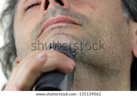 Man shaving his chin using electric shaver