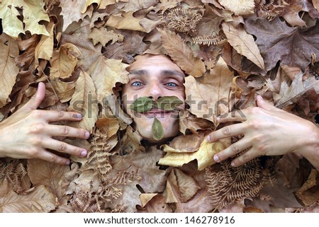 man under a bed of falling leaves, autumn concept