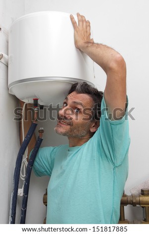 smiling plumber with electric water heater