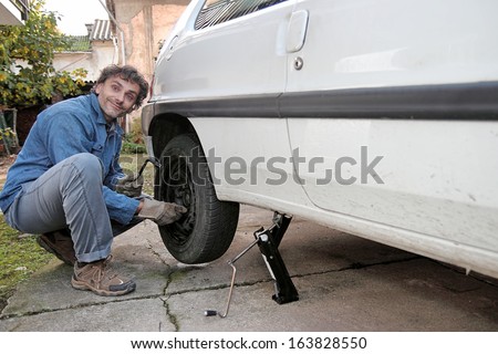 Man tighten the bolts of a car wheel