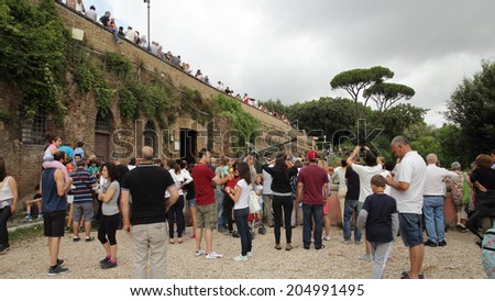 ROME, ITALY - JULY 13, 2014: People assist at the daily noon cannon fire. This tradition goes back to December 1847, when the cannon gave the sign to the bell towers to start ringing at midday.