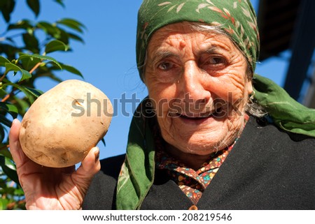 smiling senior person showing a big potato