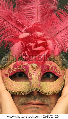 serious man with pink feathers mask