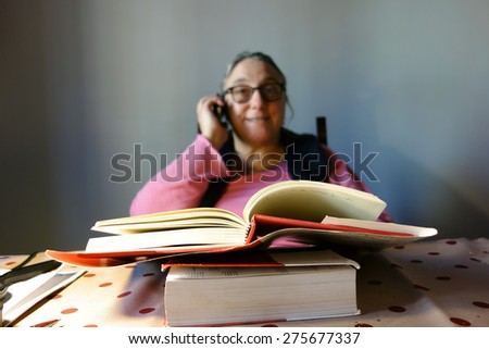 reading books concept, out of focus woman at cell phone