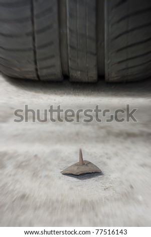 stock photo : danger on road, driving concept with tyre and nail