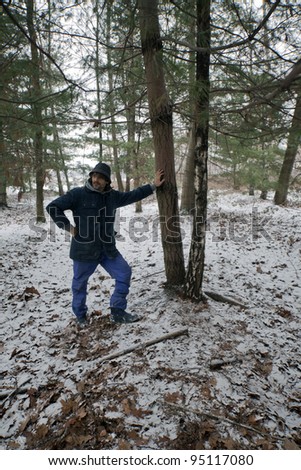 Man taking a breath during a trekking in snowy pine wood
