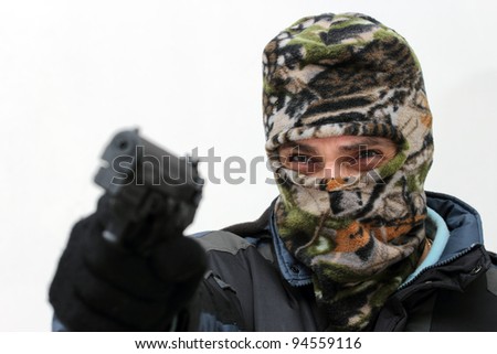 terrorist with mask aiming with his gun over white