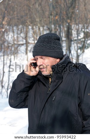 Mature man answering the phone in winter time