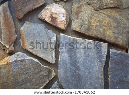 Stone finishing of a wall. Stone texture of warm colours.