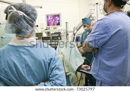 The surgeon performs surgery through electronic monitor