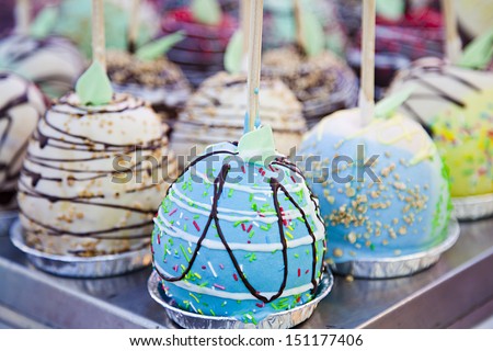 Toffee and chocolate coated apples from low perspective. Various candied apples on a stick.