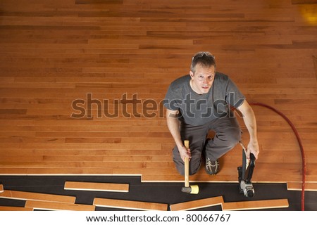 Man installing planks of hardwood floor