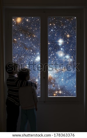 Two children look into space from a window. Elements of this image furnished by NASA.