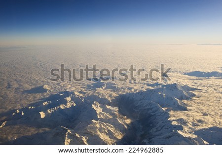 Mountain peaks rise above the cloud layer. The Alps.