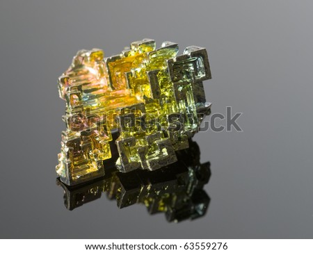 The mineral bismuth on a reflective surface